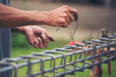 Construction Men hands bending cutting steel wire fences bar reinforcement of concrete work. Worker hands using pincer pliers iron wire. Outdoor Worker using wire bending pliers, construction workの写真素材
