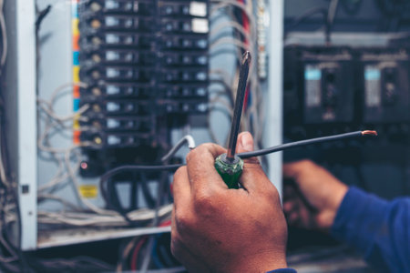 Electrical mechanic technician check wire electric cabinet. Inspector men hands working switchboard machinery maintenance service. Electrician circuit repair voltage operation. Men hands fix breakerの写真素材