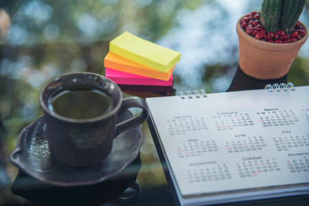 2024 Calendar event planner timetable agenda plan on organize schedule event. Wedding planner agenda organizing timetable by organizer schedule. Calendar desk objects on office table in green parkの写真素材