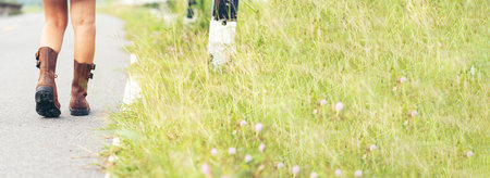 Banner Woman traveller walking on road relaxation. Women wear sneaker shoes walking summer park. Females standing green park on forest pathway outdoors. Traveler relaxing walk way with copy spaceの写真素材