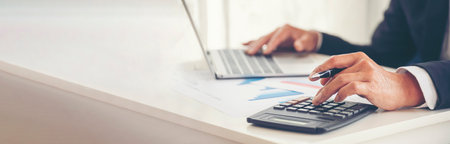 Banner Asian Business man hands using calculator counting tax financial bill. Tax audit Finacial concept. Panorama Close up businessman hands calculating number tax audit planning with copy spaceの写真素材
