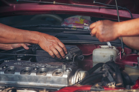 Close up Man hands fixing Car machinery vehicle mechanical service. Mechanic man hands repairing car auto repair shop. open vehicle hood checking up auto mobile. Vehicle Car maintenance engineer.の写真素材
