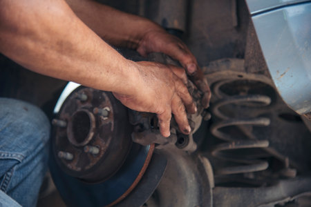 Close up Car Mechanic man hands repairing car auto repair shop. Man hands fixing machinery vehicle mechanical service. open vehicle hood checking up auto mobile. Vehicle Car maintenance engineer.の写真素材