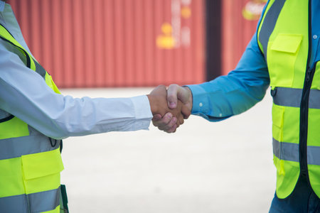Close up warehouse worker shakehand together. Engineer man hands partnership. Diversity Coworker Men logistics Warehouse teams handshake. Multiracial Support team greeting person teamwork colleaguesの写真素材