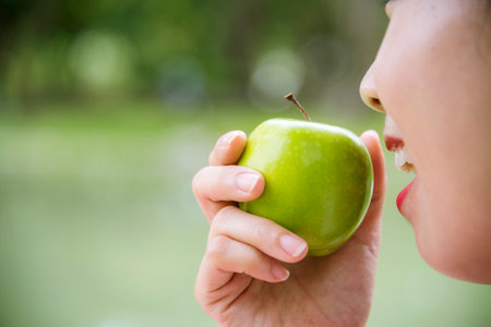 young asian woman eating Apple Healthy. Girl workout holding organic apple fruit healthy lifestyle. Wellness Asian women eat red apple smile face look at camera. Beauty health care lifestyle conceptの写真素材
