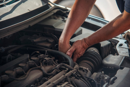 Close up Mechanic man hands repairing car auto repair shop uses jack change tyre. Man hands fixing Shock absorber machinery vehicle mechanical service. Vehicle Car overhaul maintenance engineerの写真素材