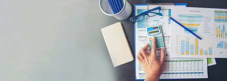 Banner woman working office desk reading financial report finance chart graph on table. Wide tax...