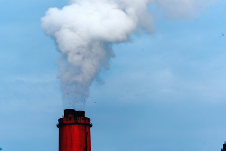 Power stations manufacturing electrical industrial plant. Electric power building refinery engineering smog steam smokestack. Lignite electricity chimneys release pollution in industry plant blue skyの写真素材