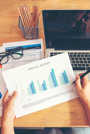 Vertical Businesswoman reading financial graph charts business info with computer laptop. Vertical horizon Women hands using laptop on office desk. Close up hands of business woman working officeの写真素材