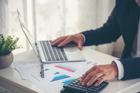 Closeup businessman hands working use laptop finance business document reading report paperwork...