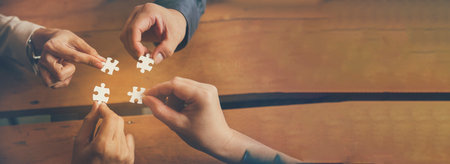 Banner Implement puzzle improve hand holding together solve synergy organize team connection plan trust strategy. Stakeholder business trust teams hands holding jigsaw puzzle synergy with copy spaceの写真素材