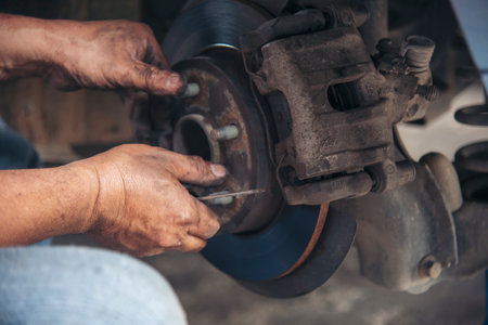 Close up Car Mechanic man hands repairing car auto repair shop. Man hands fixing machinery vehicle mechanical service. open vehicle hood checking up auto mobile. Vehicle Car maintenance engineer.の写真素材