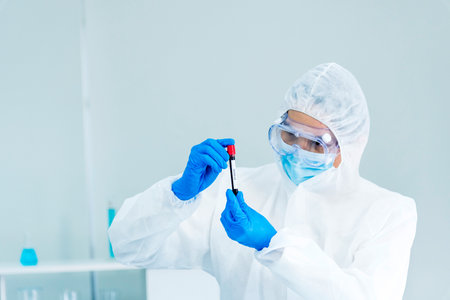 Scientist man holding sample blood test tube in science laboratory. Doctor clinic healthcare technician lab testing blood sample diagnosis. Asian man scientist working in hiv testing medical lab.の写真素材