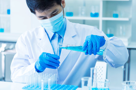 Scientist man holding sample blood test tube in science laboratory. Doctor clinic healthcare technician lab testing blood sample diagnosis. Asian man scientist working in hiv testing medical lab.の写真素材