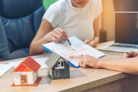 Team diversity women selling house real estate agent at office desk. Women working home insurance mortgage sale apartment realtor dealership. Businesswoman real estate house agent discuss to customerの写真素材
