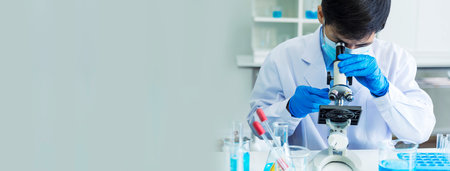 Banner Scientist man look Microscope research in science laboratory. Banner Asian scientist use microbiology microscope in laboratory equipment chemistry lab. Biochemistry experiment with copy spaceの写真素材