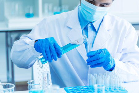 Scientist man holding sample blood test tube in science laboratory. Doctor clinic healthcare technician lab testing blood sample diagnosis. Asian man scientist working in hiv testing medical lab.の写真素材