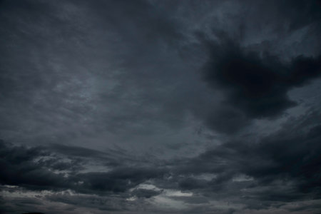 Dramatic dark storm rain clouds black sky background. Dark thunderstorm clouds rainny atmosphere. Meteorology danger windstorm disasters climate. Dark cloudscape storm disaster gloomy gray cloud skyの写真素材