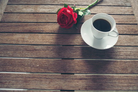 Tabletop black coffee cup red rose on wood table background with empty copy space. Espresso shot caffeine hot coffee cup in cafe. Top view Black caffeine dark beverage in cafeteria with copy spaceの写真素材