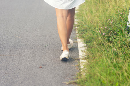 Woman traveller walking on road relaxation. Women wear sneaker shoes walking on summer park. Females standing in green park on forest pathway outdoors. Young traveler relaxing vacation in walk wayの写真素材