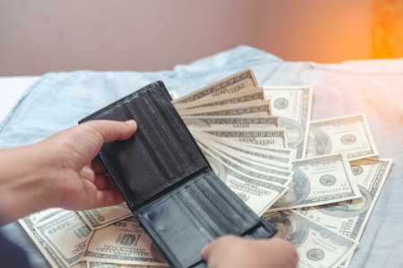 Hand holding money dollar bank note in wallet give financial payment. Man hands showing spread 100 dollar exchange cash in wallet. Saving Businessman counting money banknote concept.の写真素材