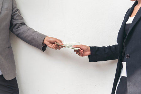 Close up hands giving money payment. Hands holding dollar bill financial economy business people.の写真素材