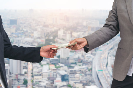 Close up hands giving money payment. Hands holding dollar bill financial economy business people.の写真素材