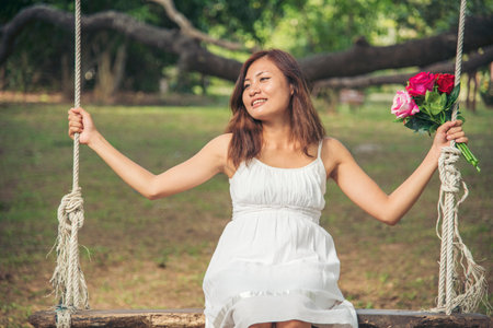Happy Relax beautiful asian woman smiling face standing in green park outdoors garden. Young women enjoy nature morning Freedom Lifestyle. woman breathing fresh air and relax breath in green parkの写真素材