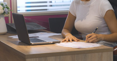 Close up Businesswoman hands type on laptop writing on notebook meeting at office desk. Crop Asian Woman Hands planning on office calendar laptop. Female hand holding pen write Business Planの写真素材
