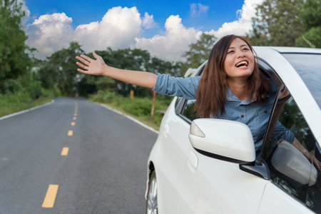 Happy asian women drive new car. Women Hand give remote control car key to man rental car service. Close up hands young woman showing new car key. Women driver giving car rental service smiling faceの写真素材
