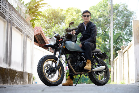 Asian man motorbike in black leather jacket travel rider trip. Handsome Men wear sunglass outdoor...