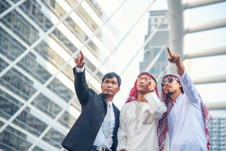 Arab team hold digital tablet uae union teamwork people. Digital marketing arab group of people using smart tablet discuss modern muslim UAE city. Entrepreneur Asian people smile teams meeting.の写真素材