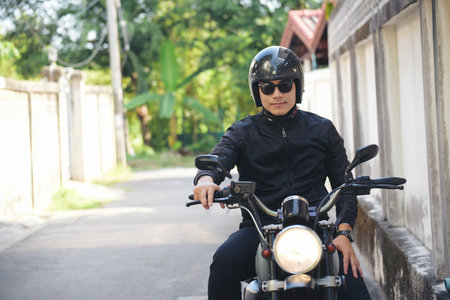 Asian man motorbike in black leather jacket travel rider trip. Handsome Men wear sunglass outdoor...