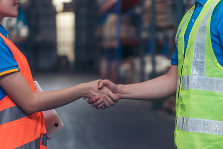 Close up warehouse worker shakehand together. Engineer man hands partnership. Diversity Coworker Men logistics Warehouse teams handshake. Multiracial Support team greeting person teamwork colleaguesの写真素材