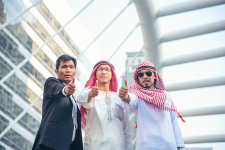 Arab team hold digital tablet uae union teamwork people. Digital marketing arab group of people using smart tablet discuss modern muslim UAE city. Entrepreneur Asian people smile teams meeting.の写真素材