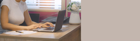 Banner Businesswoman hands type on laptop writing on notebook meeting at office desk. Banner Asian Woman Hands write planning office laptop. Female hand holding pen plan business with copy spaceの写真素材