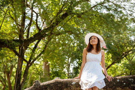 Portrait Asian Woman relaxing in green park. Happy Relax asian woman smiling face at outdoors garden. Young women enjoy nature freedom lifestyle. Greenery wellbeing outside beauty in nature.の写真素材