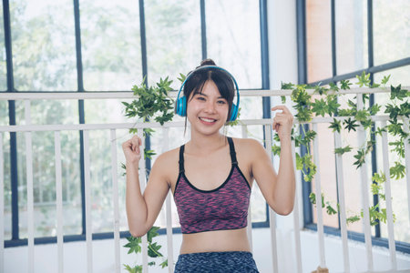 Yoga woman workout in sportswear sit on yoga mat home fitness workout exercise. Happy beauty women dance on floor use headphone listen to music wellness lifestyle. Beautiful woman smile listen musicの写真素材