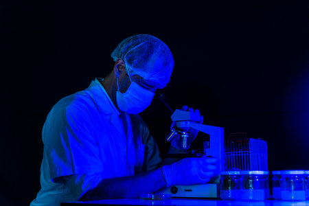 Scientist men in lab look at science microscope medical test researching biology chemistry with blue...