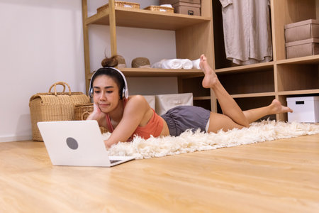 Young Sport Women look at laptop online trainer home fitness workout exercise in living room. Woman using laptop on floor in sportswear arms stretching body weight traning. Healthy lifestyle conceptの写真素材