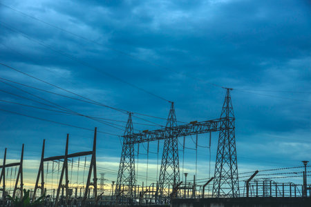 High voltage pole electric wiring distribution landscape energy engineering. Electricity energetic background with blue sky green mountain in countryside. Electric power energy engineering industrialの写真素材