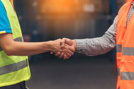 Close up Engineer man hands shakehand together Warehouse partnership. Diversity Coworker Men warehouse worker logistics teams handshake. Multiracial Support team greeting person teamwork colleaguesの写真素材