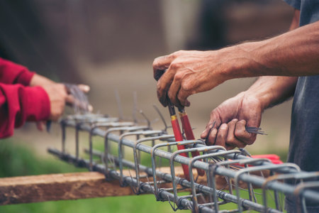 Construction Men hands bending cutting steel wire fences bar reinforcement of concrete work. Worker...