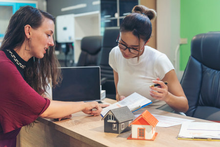 Team diversity women selling house real estate agent at office desk. Women working home insurance...