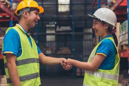 Close up warehouse worker shakehand together. Engineer man hands partnership. Diversity Coworker Men...
