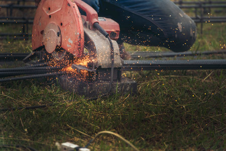 Construction Worker hands using Welding machinery iron metal sparking. Men hands wear protective glove Hot flame metal work cutting fire iron workshop. Locksmith use Welding machine cut metal processの写真素材
