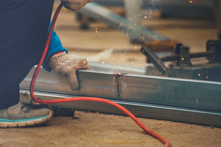 Men hands wear protective glove Hot flame metal work cutting fire iron workshop. Locksmith use...