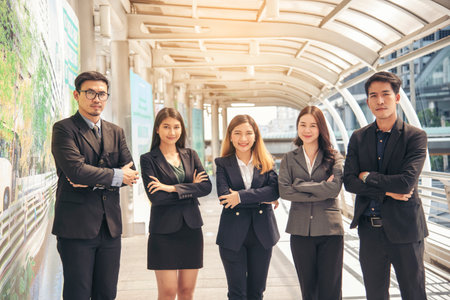 Portrait Group of businesspeople arms crossed smiling look at camera in modern city background....