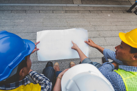 Contractor construction engineer meeting talking together on architect table at construction office...