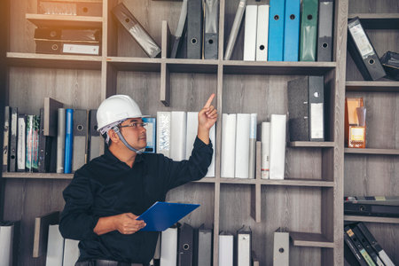 Man construction engineer writing note wear blue shirt safety white hard hat at construction site....